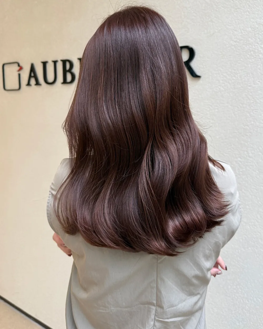 自然なツヤを見せるブラウンのウェーブヘアの後ろ姿